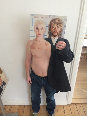 a man standing in front of a poster of a shirtless man