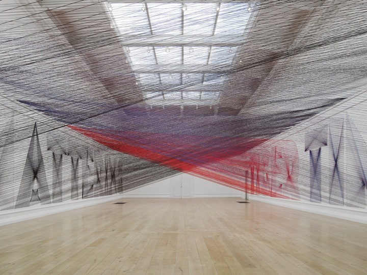 a large room with a wooden floor and a painting on the wall