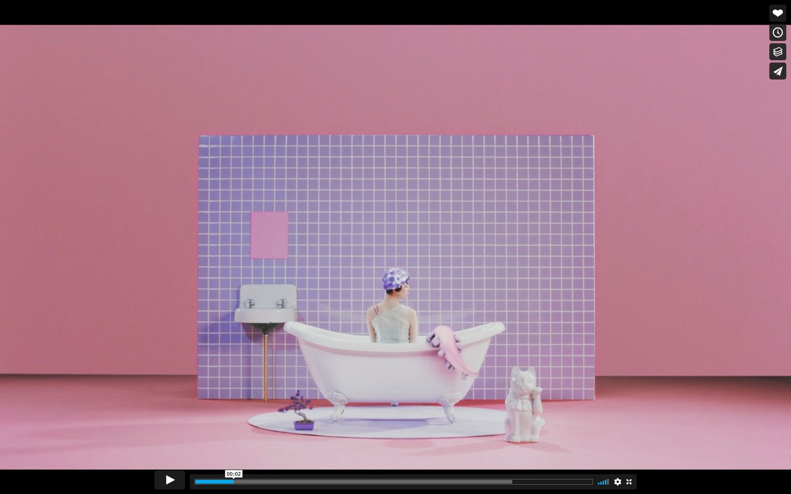 a woman sitting in a bathtub in a pink bathroom