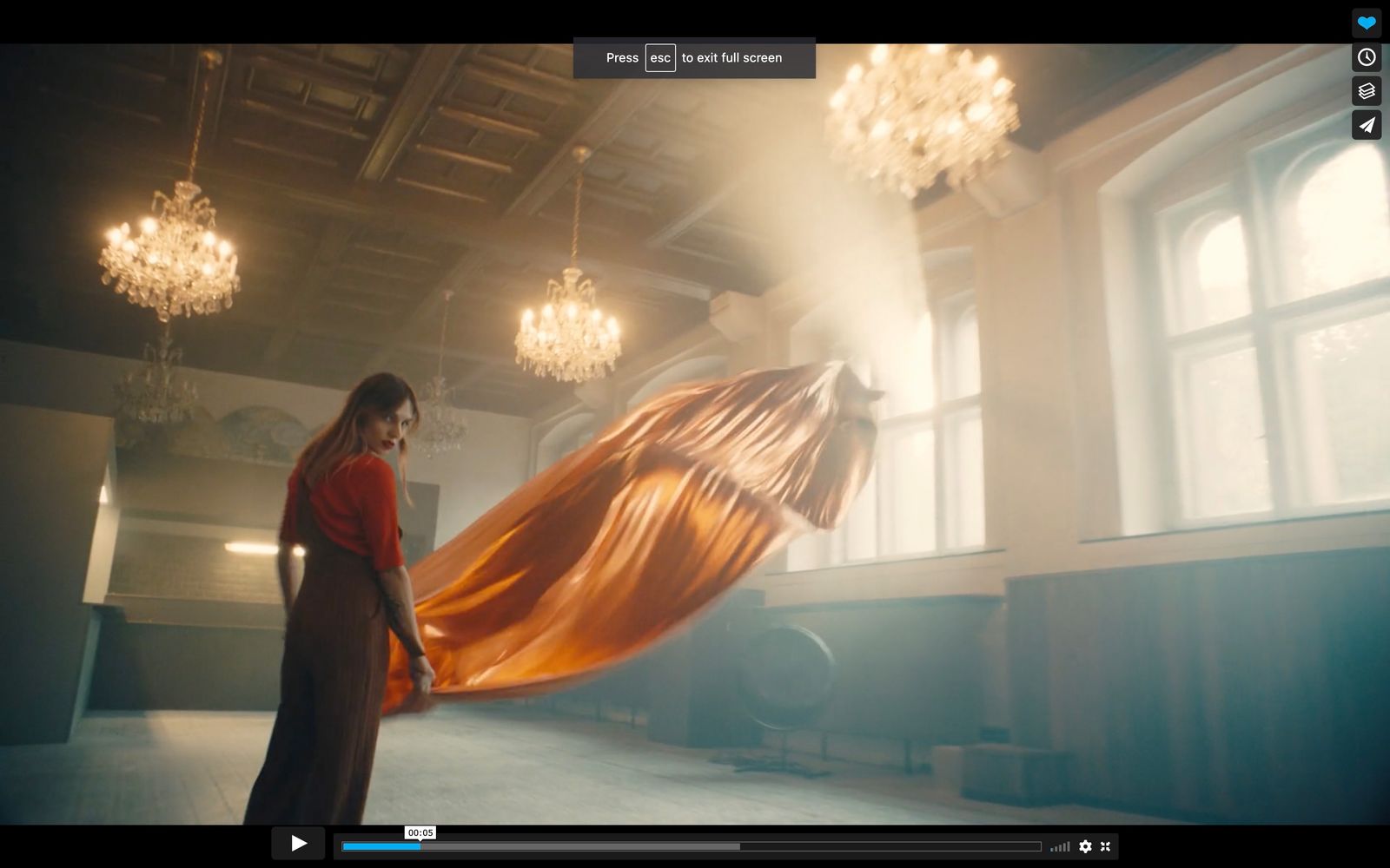 a woman standing in a room with a long orange dress