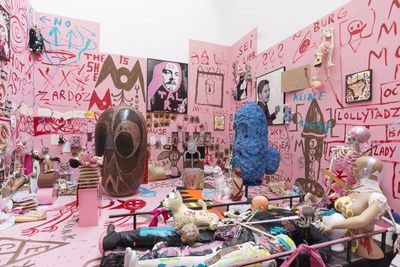 a room filled with mannequins and a pink wall