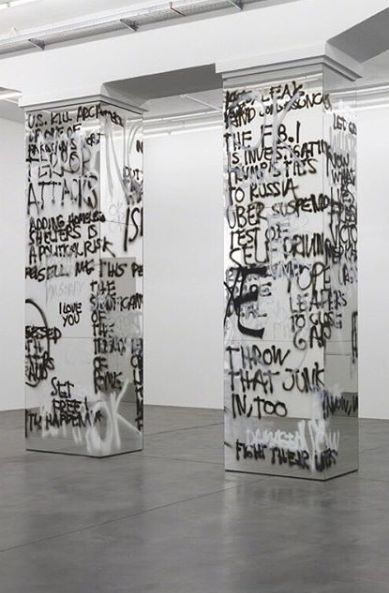 a couple of tall white pillars with graffiti on them