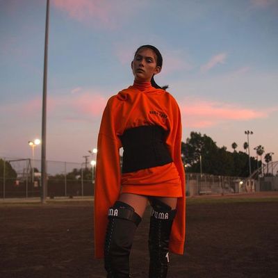 a woman in an orange outfit standing on a baseball field