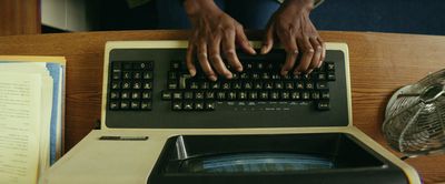 a person typing on a computer keyboard on a desk