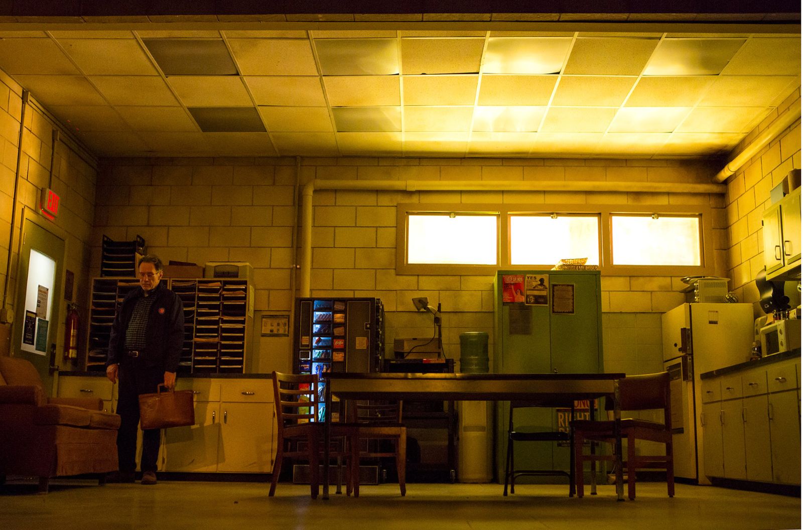 a man standing in a kitchen next to a table