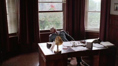 a man sitting at a desk in front of a window