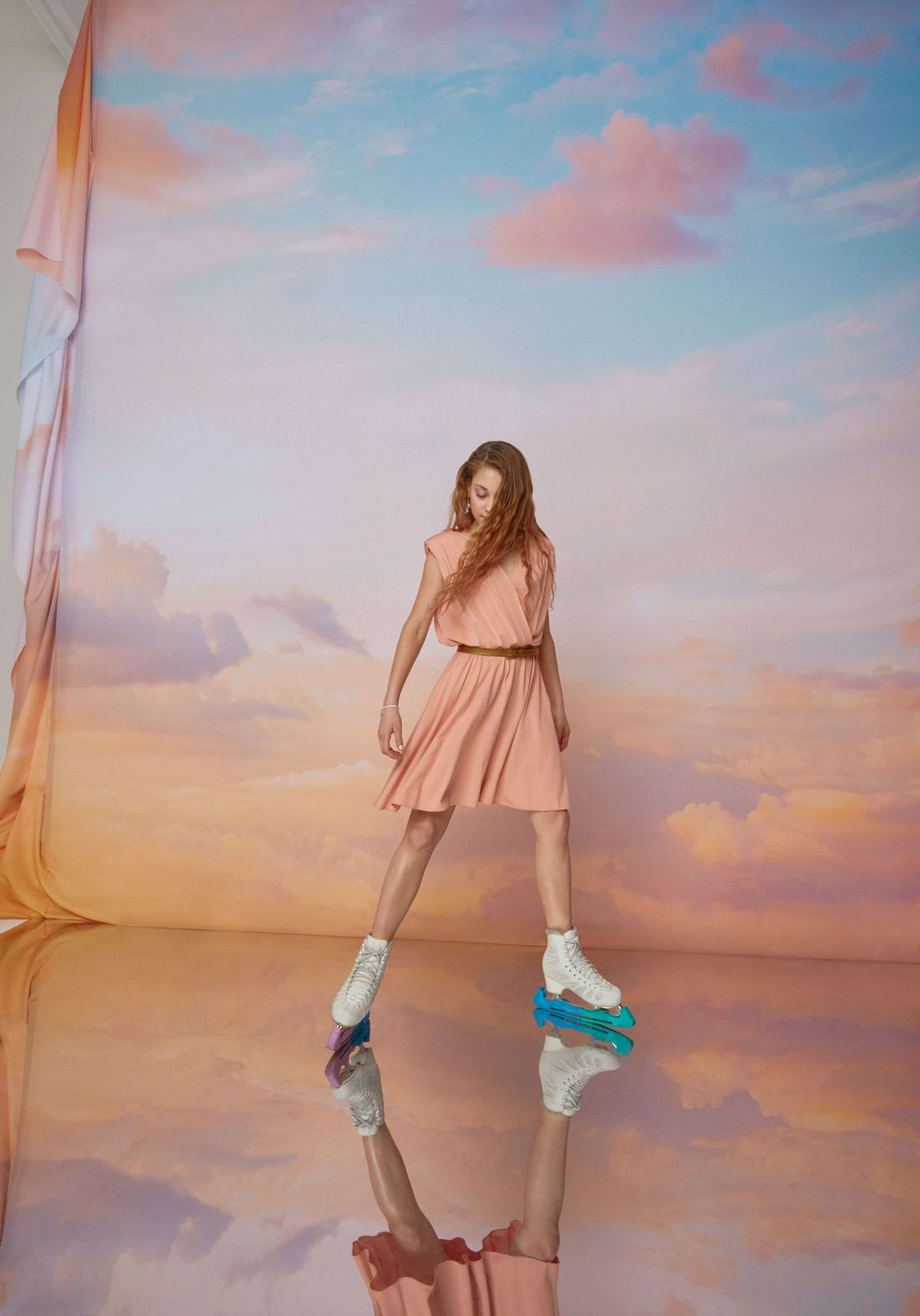 a woman in a pink dress is standing in front of a backdrop