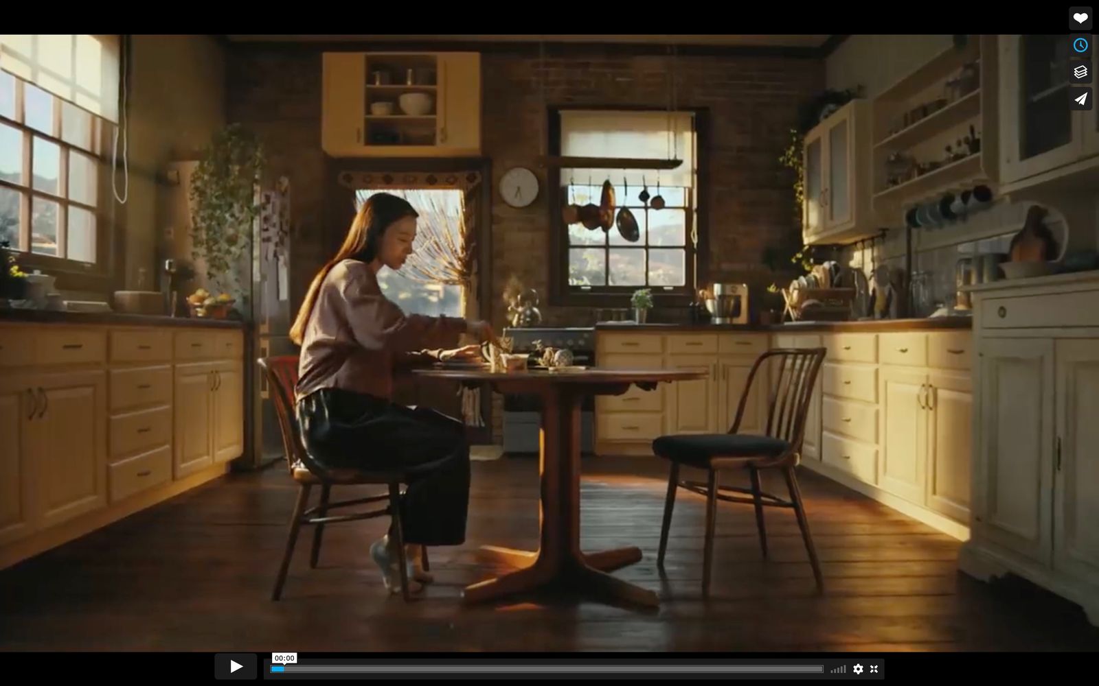 a woman sitting at a table in a kitchen