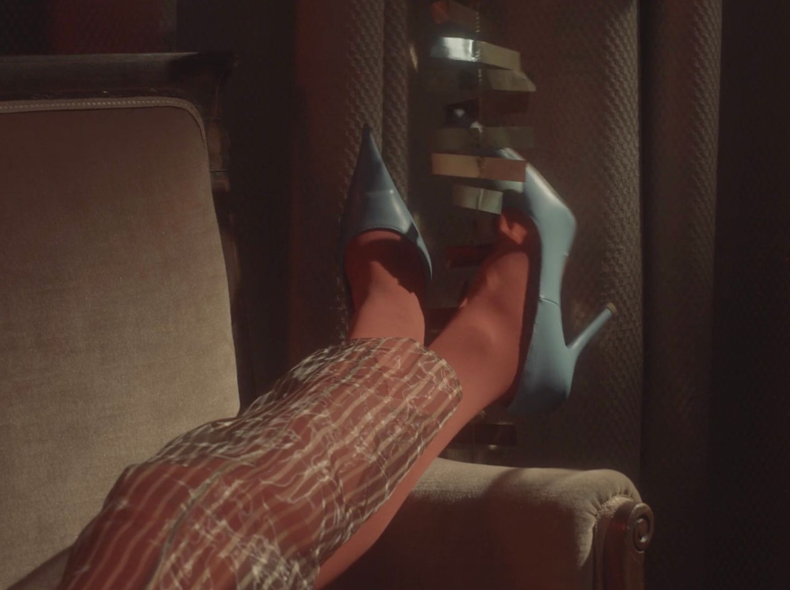 a person's feet resting on a chair in a room