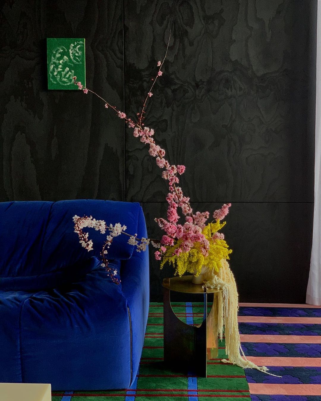 a blue couch sitting next to a vase with flowers