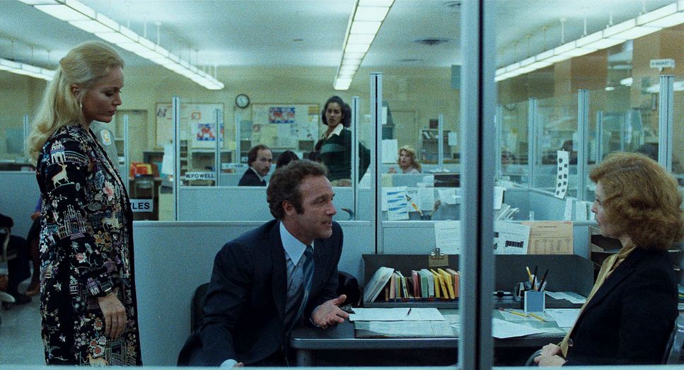 a man and woman sitting at a desk in an office