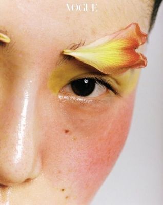 a close up of a person with a flower on their forehead