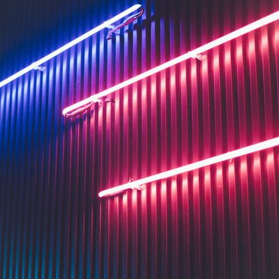 a red and blue light shines brightly on a building