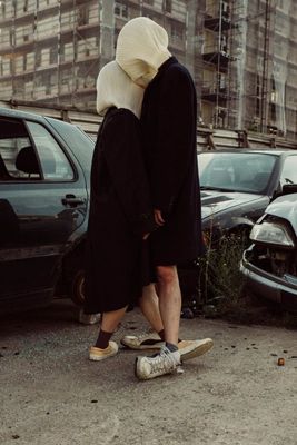 a person in a black dress and a person in a white mask