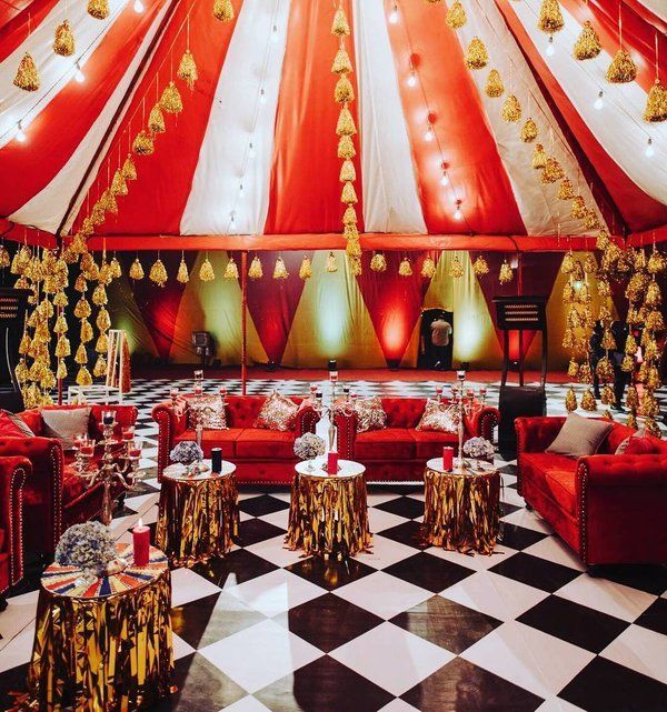 a large tent with a checkered floor and red couches