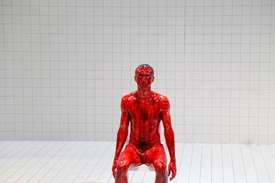 a red man sitting on top of a white toilet