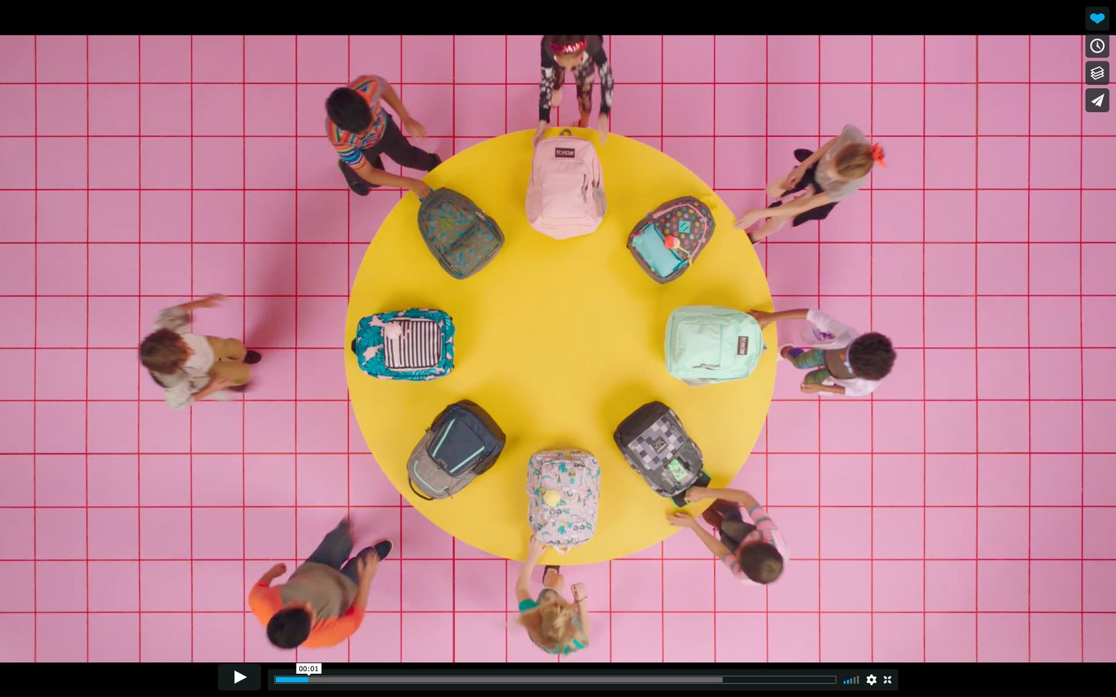 a group of people standing around a yellow table