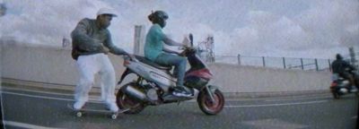 a man and a woman riding a motor scooter