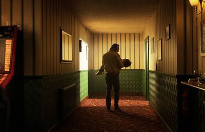 a man standing in a hallway next to a slot machine