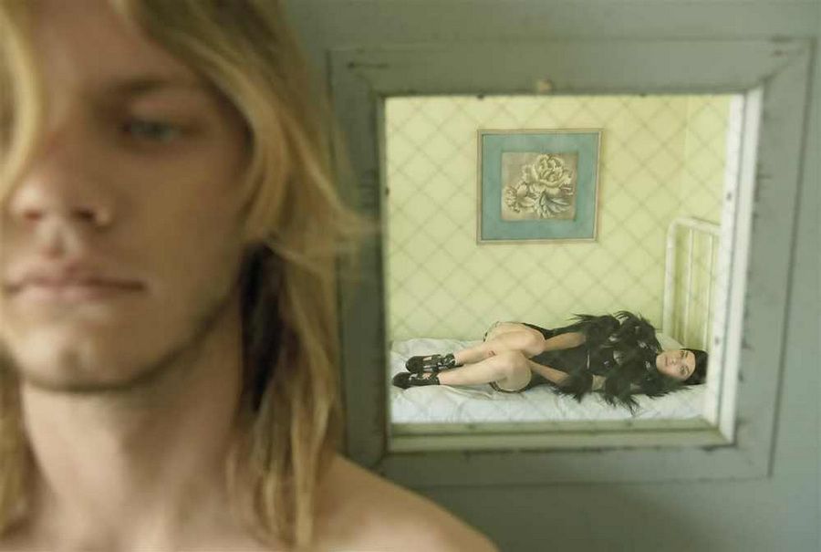 a woman laying on a bed in front of a mirror