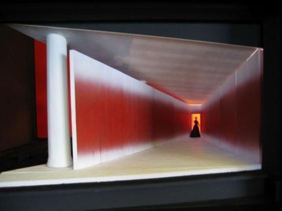 a person standing in a tunnel with red walls