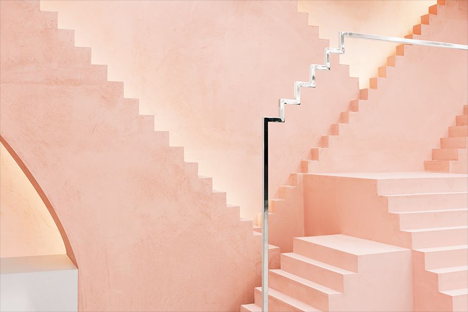 a staircase with a light pink wall and white steps