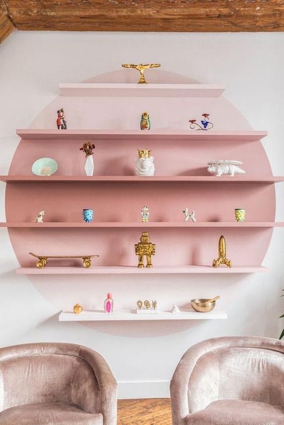 a couple of chairs sitting in front of a pink shelf