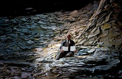 a man sitting on a rock holding a piece of paper