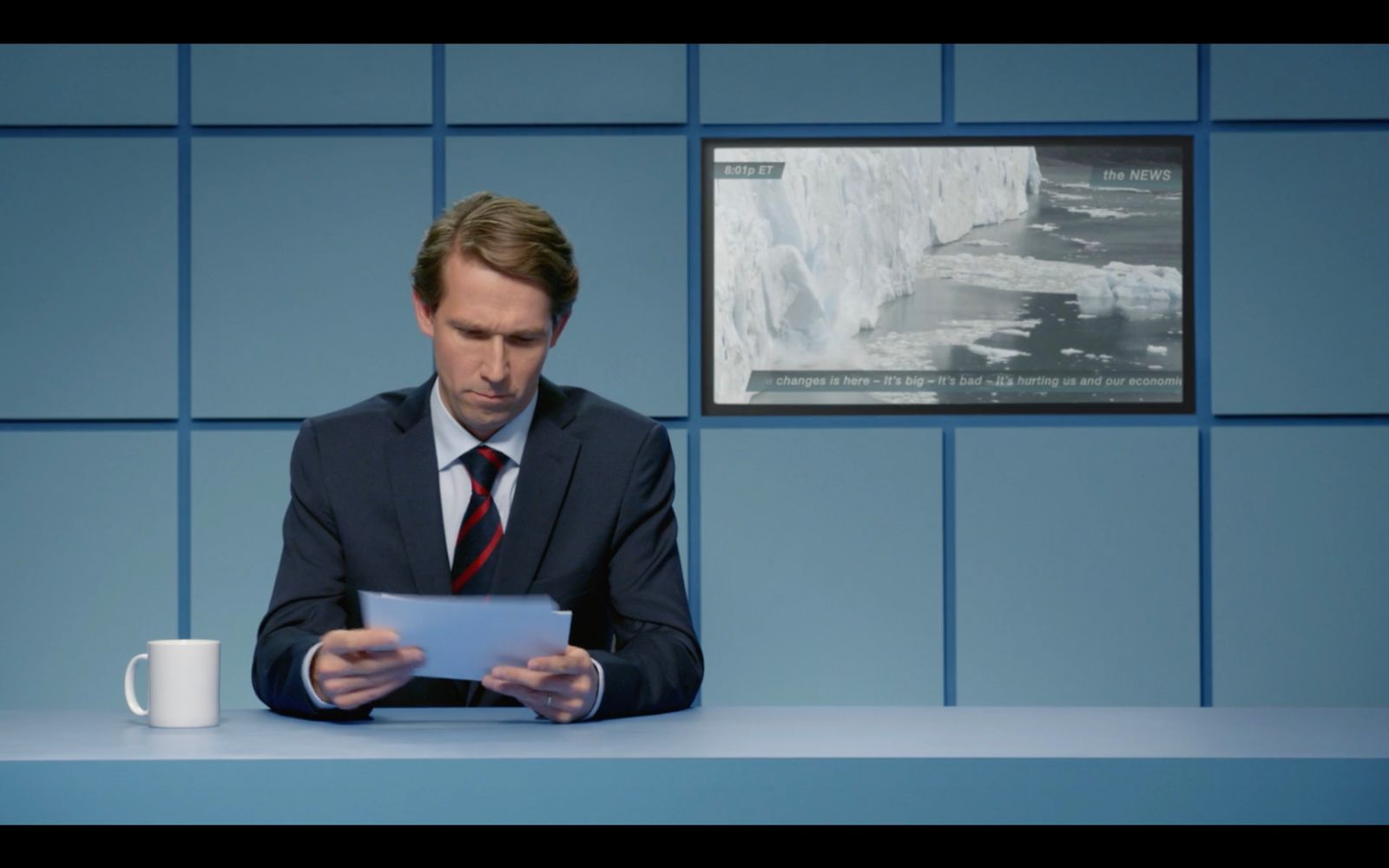 a man in a suit and tie sitting at a table with a tablet