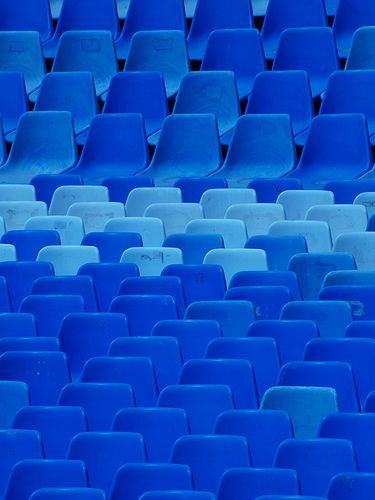 a row of blue seats in a stadium