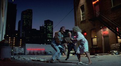 a group of people walking down a street at night