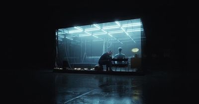 two people sitting at a table in a dark room