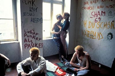 a group of people sitting in a room with graffiti on the walls