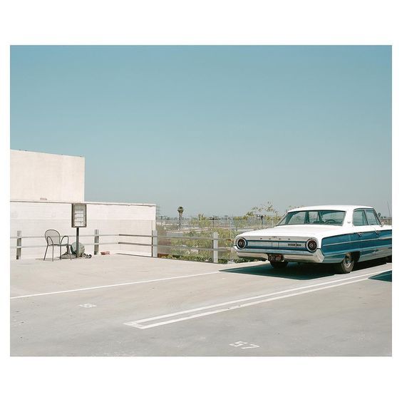 a white and blue car parked on the side of a road