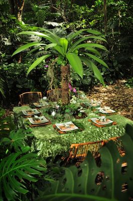 a table with a green table cloth and place settings