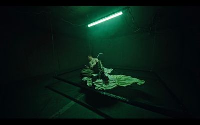 a woman sitting on a bed in a dark room