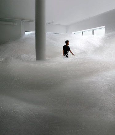 a man standing in a room filled with white stuff