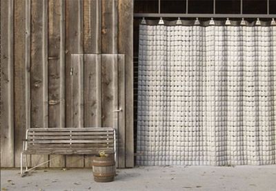 a wooden bench sitting next to a white curtain