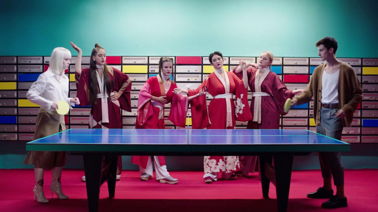 a group of people standing around a ping pong table