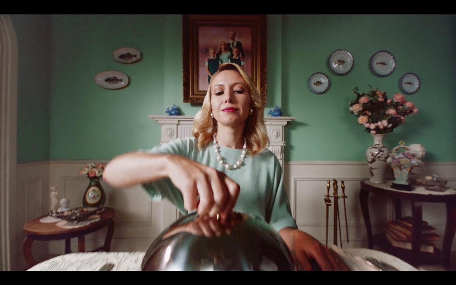 a woman sitting on a bed holding a tea kettle