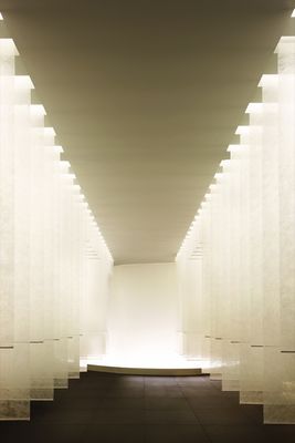 a long hallway with white columns and lights