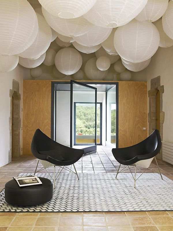 a living room with a lot of white paper lanterns hanging from the ceiling