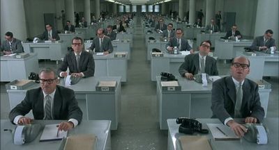 a group of men sitting at desks in a room