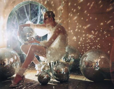 a woman sitting on top of disco balls