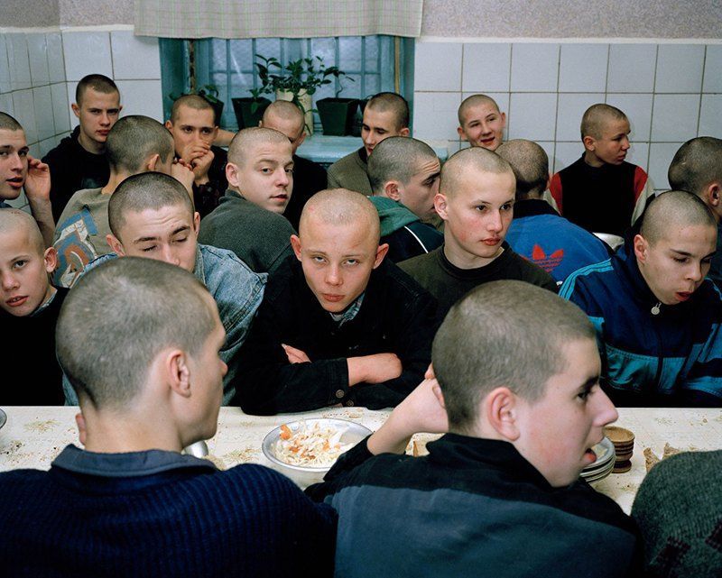 a group of men sitting around a table eating food