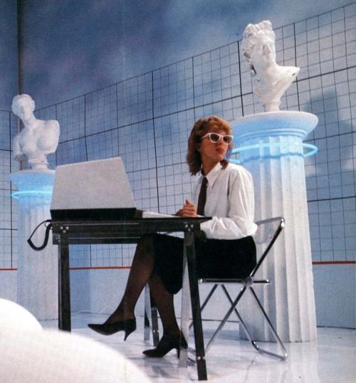 a woman sitting at a desk in front of a laptop computer