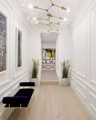 a long hallway with white walls and a blue bench