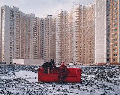 a woman sitting on a red couch with a dog