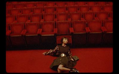 a woman laying on the floor in front of a red chair