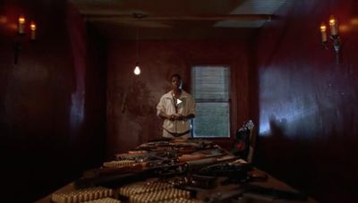 a man standing next to a table full of guns